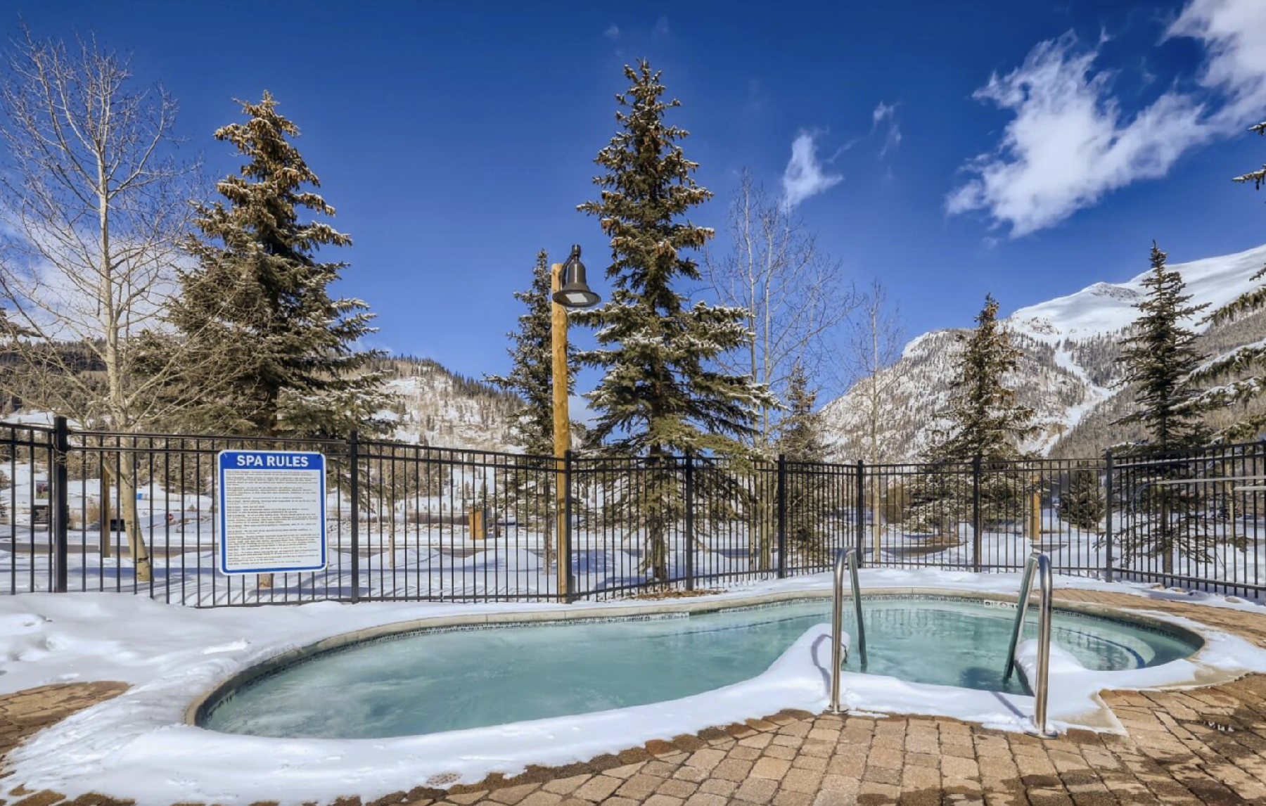 Outdoor hot tub at Copper Springs Condos in Copper Mountain, Colorado, surrounded by snow with mountain views under a cl