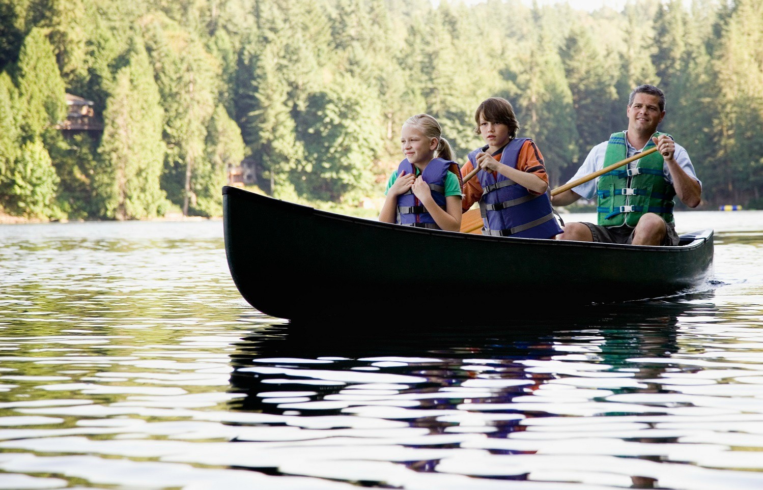 Family Kayaking on Lake Dillon With Pine Trees in the Backdrop