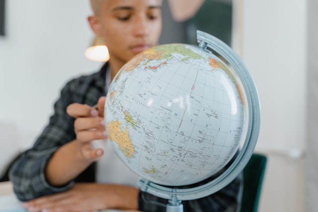 person looking at a globe