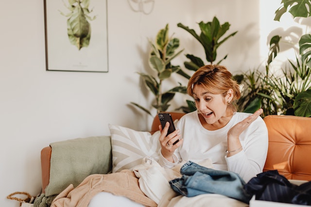 person sitting on an orange couch FaceTiming their pet