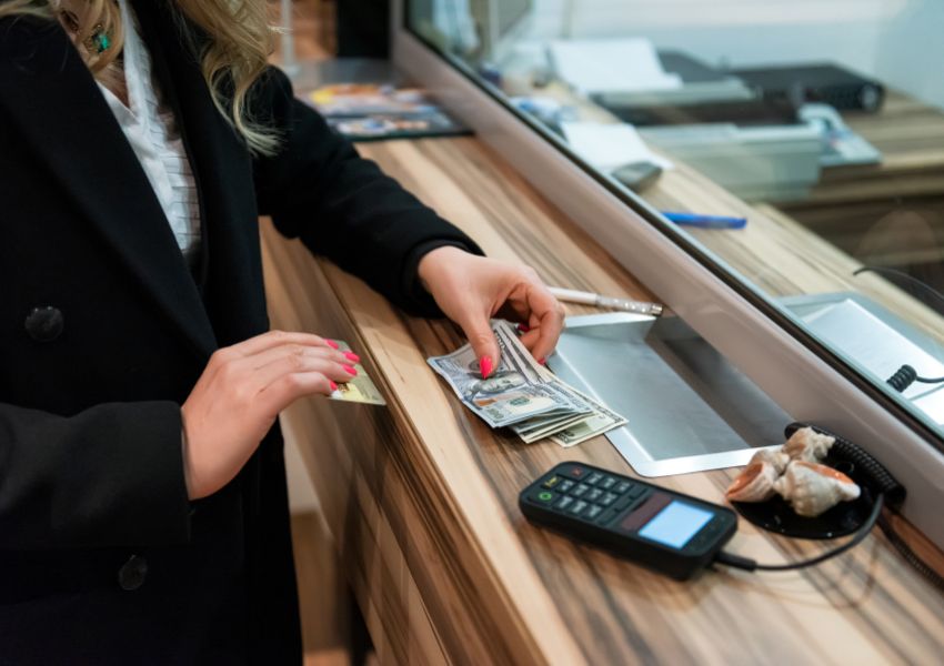 Person exchanging cash at an exchange booth